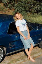 Laden Sie das Bild in den Galerie-Viewer, femme portant t shirt tiga logo bleu fond blanc vintage sur une belle voiture